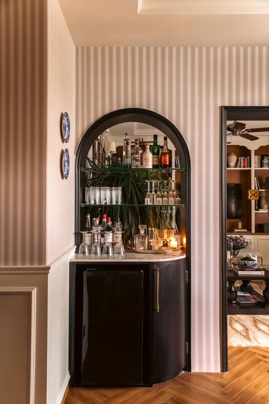 Arched bar nook set into striped wallpaper